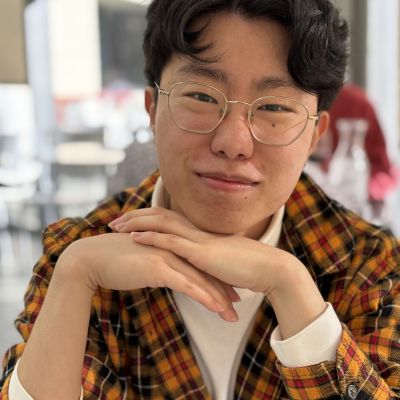 person in a plaid blazer and glasses